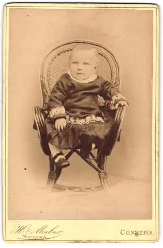 Fotografie Herm. Moebes, Cönnern, Kleinkind auf Stuhl