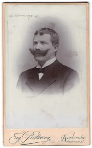 Fotografie Eug. Butterweg, Karlsruhe, Amalienstr. 37, Porträt eines Mannes mit beeindruckendem Schnurrbart