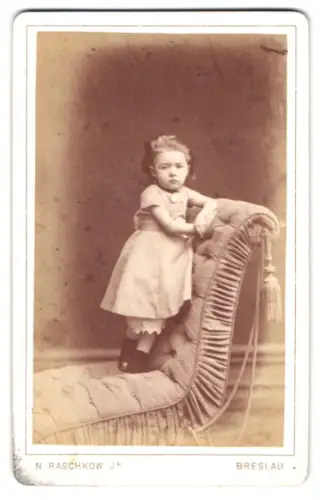 Fotografie N. Raschkow Jr., Breslau, Schweidnitzer Stadtgraben 9, Kind auf gepolsterter Chaiselongue
