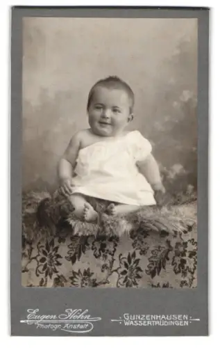 Fotografie Eugen Höhn, Gunzenhausen, Kleinkind in weissem Tuch auf gemustertem Stoff