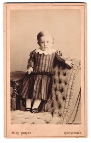 Fotografie Alex Putzar, Greifswald, Bahnhofstrasse 53, Kind im gestreiften Kleid auf Sessel