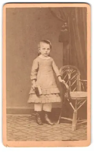 Fotografie Georg Gronemann, Walsrode, Kleines Mädchen mit Buch neben Stuhl