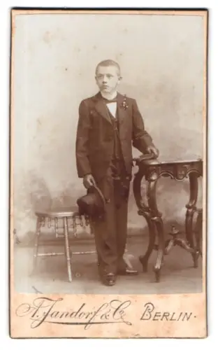 Fotografie A. Jandorf & Co., Berlin, Grosse Frankfurter Str. 113, Junge mit Zylinder und Tisch