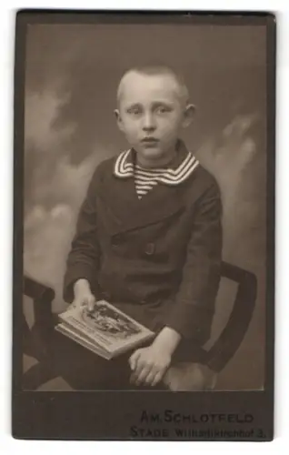 Fotografie Am. Schlotfeld, Stade, Wilhadikirchhof 3, Porträt eines Jungen mit Buch