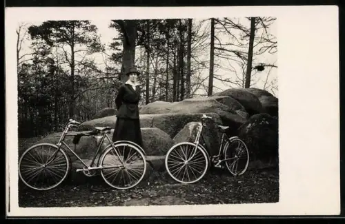 Foto-AK Dame mit Fahrrad vor einer Felsformation