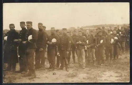 AK Kriegsgefangene in Uniform mit Tellern