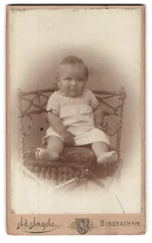 Fotografie Ad. Angele, Biberach a/R, Am Bahnhof, Kleinkind auf Stuhl