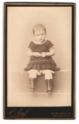 Fotografie Carl Ruf, Karlsruhe, Amalienstr. 26, Kind in feinem Kleid auf einer Sitzbank