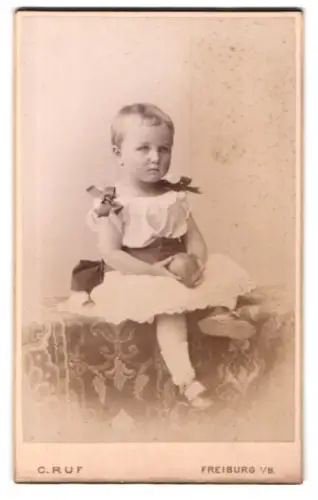 Fotografie C. Ruf, Freiburg, Kaiserstrasse 5, Kleinkind im weissen Kleid mit Ball