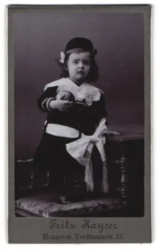 Fotografie Fritz Kayser, Hannover, Nordmannstr. 12, Kind in dunklem Kleid mit Ball