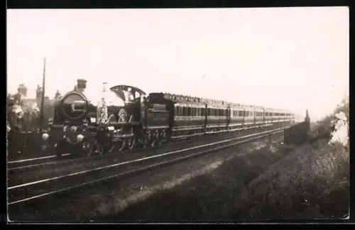 AK Britische Lokomotive mit Tender und Personenwaggons wird von Mädchen vom Bahndamm aus beobachtet, englische Eisenbahn