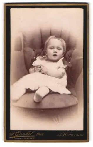 Fotografie J. Gunkel, Heidelberg, Anlage 25, Porträt eines kleinen Kindes auf einem gepolsterten Stuhl