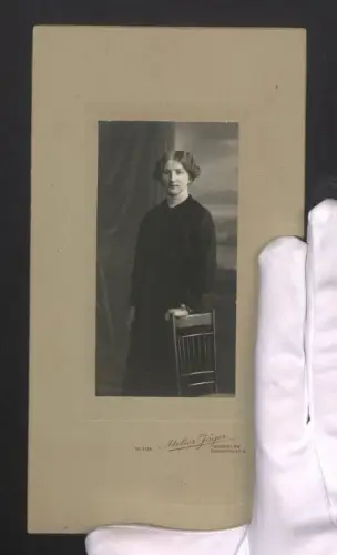 Fotografie Atelier Jäger, Würzburg, junge Frau im dunklen Kleid vor einer Studiokulisse