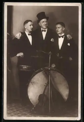 Foto-AK Drei elegant gekleidete Musiker stehen an einer Trommel