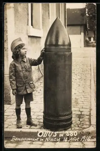 AK Junges Kind in Uniform neben einem riesigen Artilleriegeschoss
