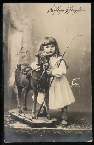 AK Kind mit Peitsche umarmt ein Schaukelpferd
