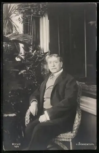 AK Schauspieler von Sonnental sitzt auf einem Korbstuhl