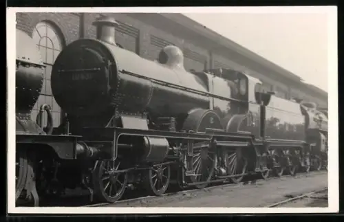 AK Britische Lokomotive Nr. 1040 der LMS mit Tender und anderen Lokomotiven in einem Bahndepot, englische Eisenbahn