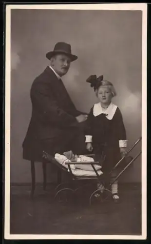 Foto-AK Mann mit seiner Tochter und ihrem Kinderwagen, in dem eine Puppe liegt