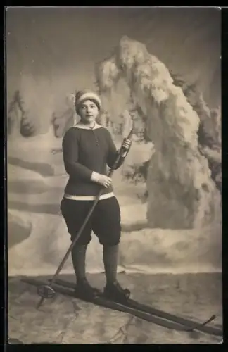 Foto-AK Frau auf Ski vor einem verschneiten Hintergrund