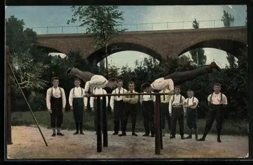 AK Herren beim Turnen am Barren unter einer Brücke