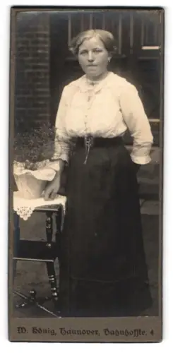 Fotografie W. König, Hannover, Bahnhofstrasse 4, Frau neben Tisch mit Pflanze