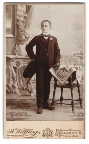 Fotografie H. Wolffberg, Rixdorf, Bergstrasse 9, Junge mit Hut neben Tisch