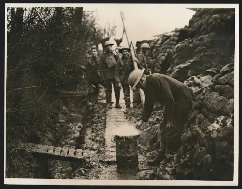 Fotografie englischer Soldat bereitet sich Speck in der Pfanne im Schützengraben zu, Frying bacon in a reserve trench