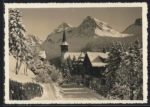 AK Arosa, Dorfstrasse mit Kirche im Winter