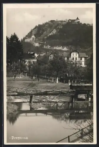 AK Pitten /N.-Ö., Ortsansicht mit Burg auf Felsen, Brücke und Fluss