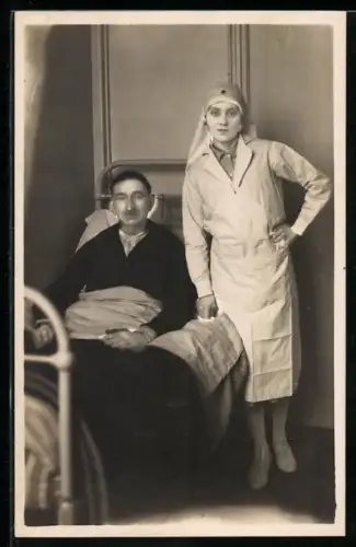 Foto-AK Schwester des Roten Kreuzes an einem Krankenbett