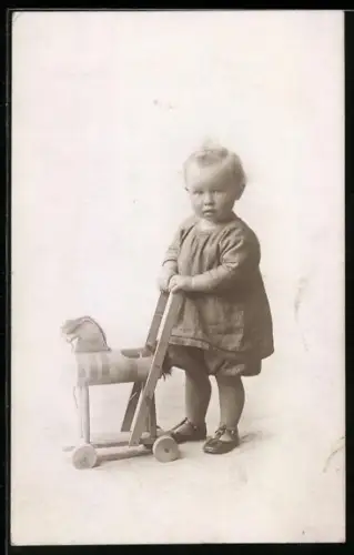 Foto-AK Kleinkind mit einem Schaukelpferd