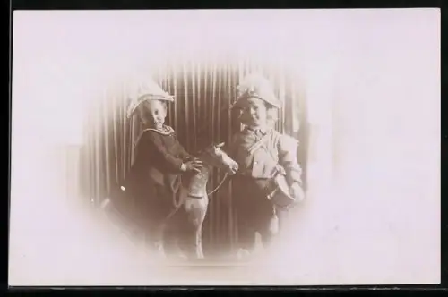 Foto-AK Zwei Kinder, eines auf einem Schaukelpferd, das andere mit Trommel