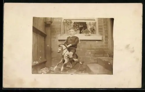 Foto-AK Junge sitzt auf einem Schaukelpferd