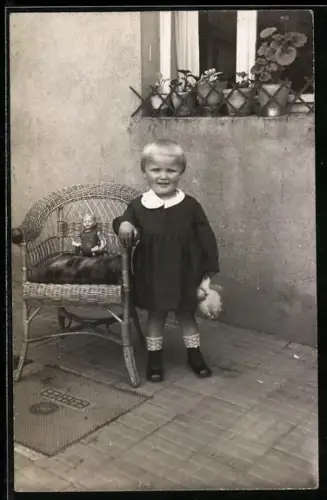 Foto-AK Kleines Kind am Korbstuhl mit Puppe