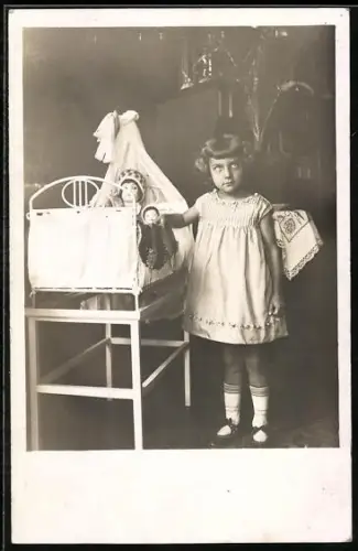 Foto-AK Kleines Mädchen mit Puppe an der Wiege, 1934