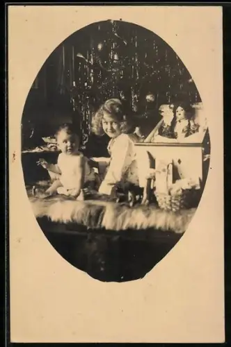 Foto-AK Zwei Kinder mit Puppe am Weihnachtsbaum