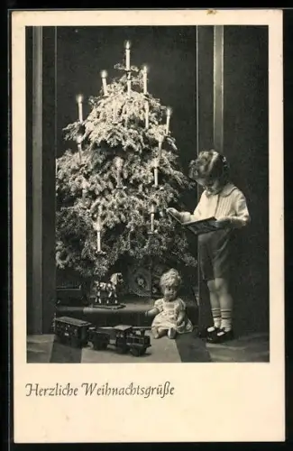 AK Weihnachten, Kind beim Anschauen eines Buches und Spielzeug unter dem Weihnachtsbaum