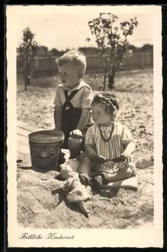 AK Kinderpaar im Sandkasten mit Puppe