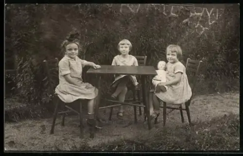 Foto-AK Drei Mädchen mit Puppe am Tisch, 1927