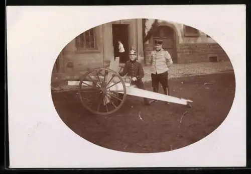 Foto-AK Zwei Männer mit Kanonenatrappe 1913, Studiokulisse