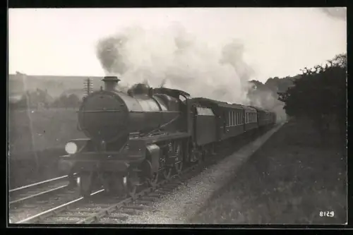 AK Britische Lokomotive mit Kohlentender fährt mit starker Rauchentwicklung, englische Eisenbahn