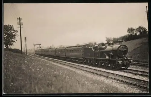 AK Britische Lokomotive Nr. 704 mit acht Personenwaggons in Fahrt, englische Eisenbahn