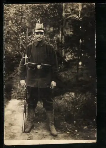 Foto-AK Soltau, Kriegsgefangenenlager, Landsturm-Wachsoldat mit Tschako, Koppeltaschen und Gewehr 88