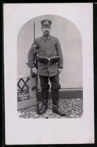 Foto-AK Soltau, Kriegsgefangenenlager, Landsturm-Wachsoldat mit Schirmmütze, Koppeltaschen und Gewehr 88