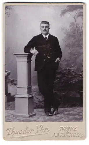 Fotografie Theodor Yhr, Rønne, Eleganter Herr mit Säule