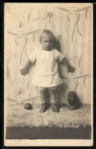 Foto-AK Kleinkind mit Ball und Büste vor gemusterter Tapete