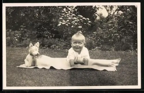 Foto-AK Kleinkind mit Hundespielzeug auf einer Decke