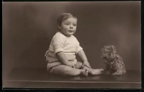 Foto-AK Sitzendes Kleinkind mit Hunde-Plüschtier