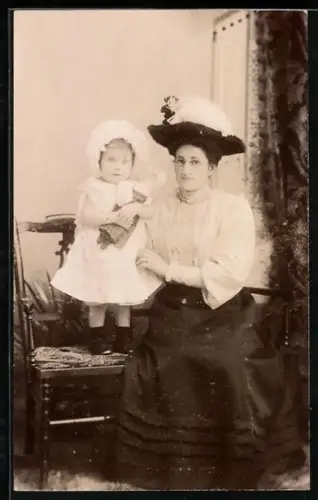 Foto-AK Mutter und Tochter, die auf einem Stuhl steht und eine Puppe hält